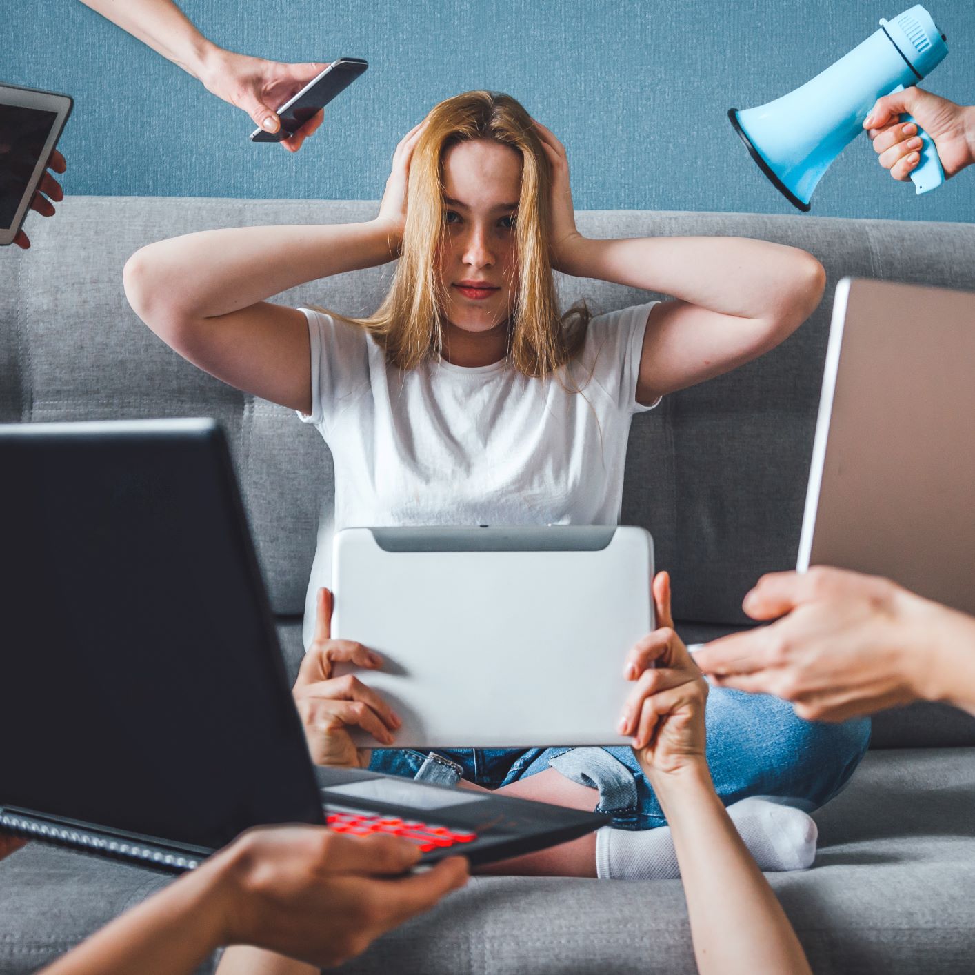 Femme qui grimace avec plein d'outils électroniques autour d'elle 
