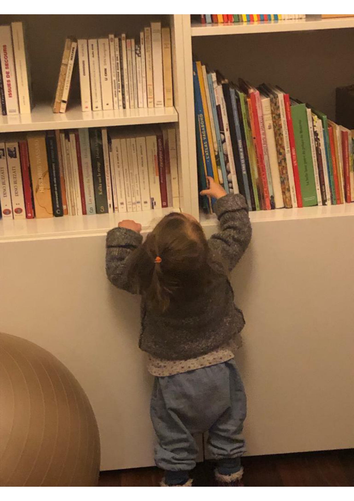 petite fille devant une bibliothèque